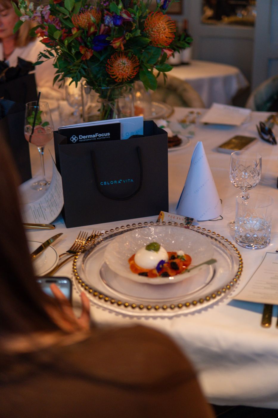 A dinner table laid with gift bags and plated desserts